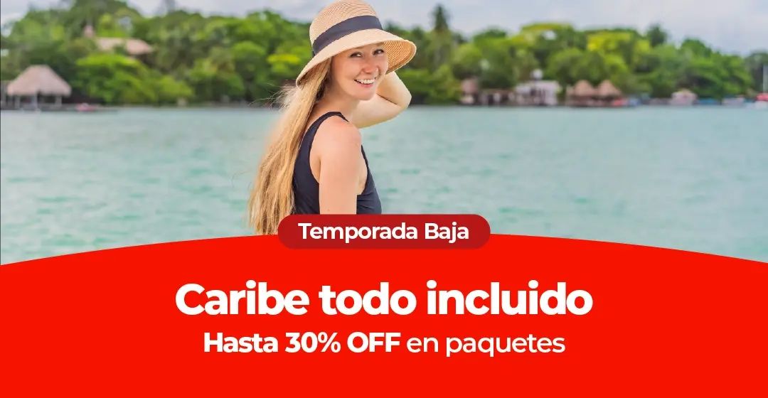 Mujer con sombrero de paja sonriendo junto a un lago tropical con vegetación.