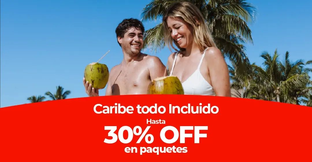 Una pareja sonríe en la playa sosteniendo cocos bajo palmeras.