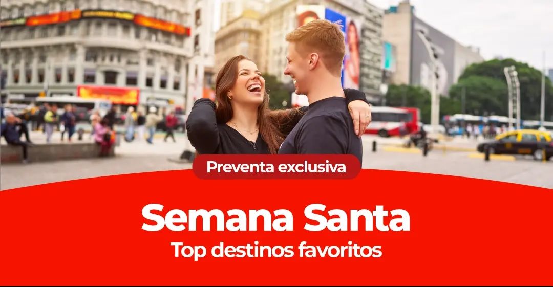 Una pareja riendo y abrazándose en una concurrida calle de la ciudad.