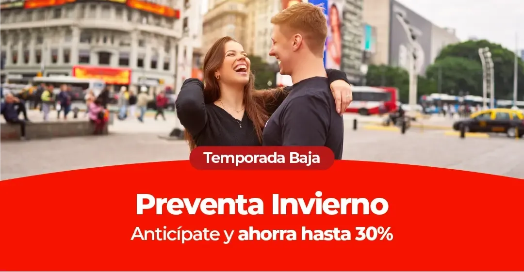 Una pareja sonriente se abraza en una calle concurrida de la ciudad.