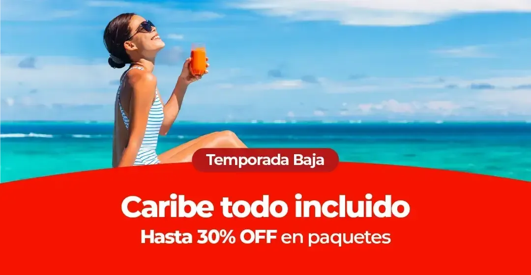 Mujer en bañador y gafas de sol sostiene una bebida frente al mar.