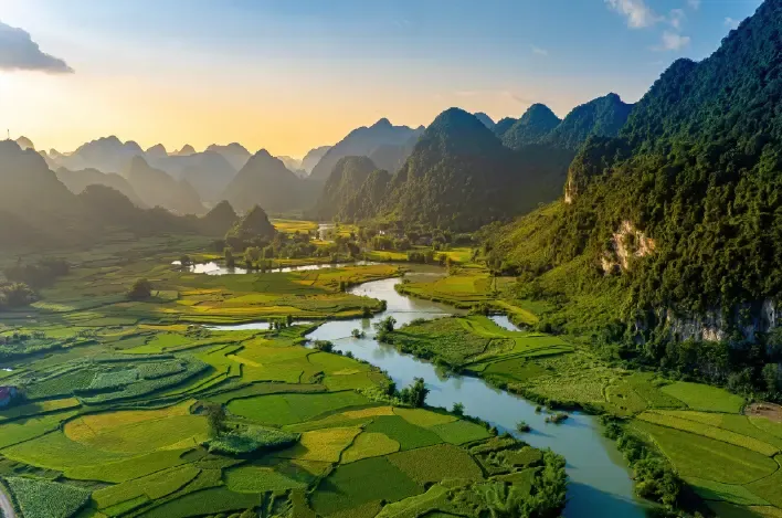 Paisaje de valle con río, campos de arroz aterrazados y montañas.