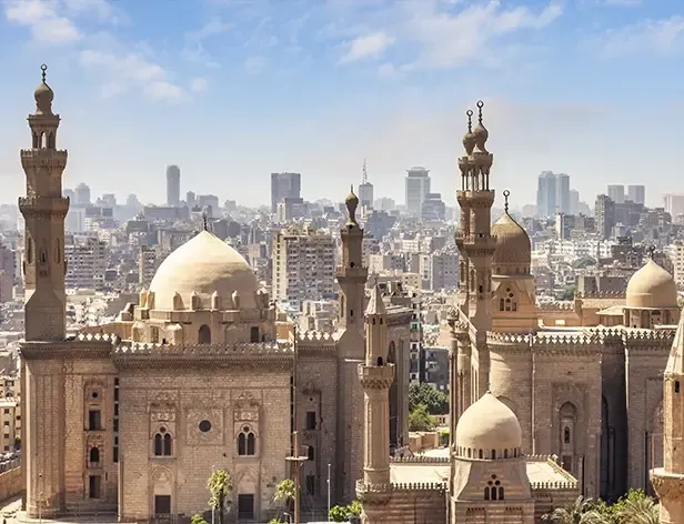 Antiguas mezquitas con minaretes y cúpulas en un horizonte urbano.