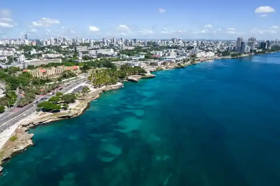 Ciudad costera con edificios, carretera y aguas azul turquesa.